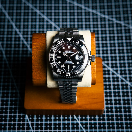 montre seiko mod GMT un cadran noir, equipé d'un bracelet jubilé en acier inox